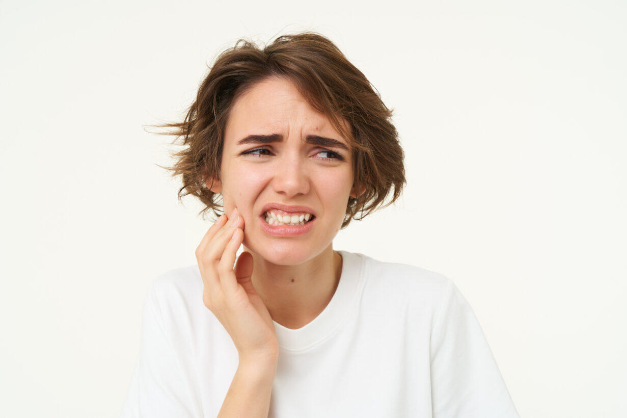 Person experiencing tooth pain seeking emergency dental care